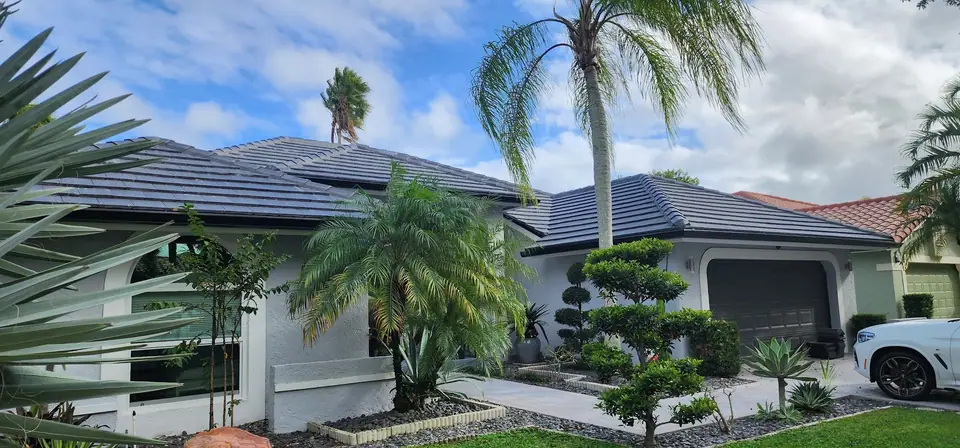 South Florida homes with grey tile roofs and new gutters, under palms