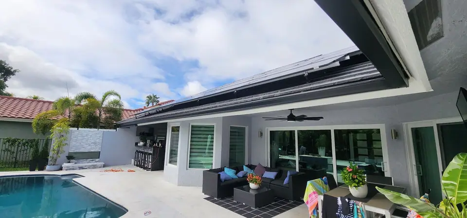 A dark gutter along a modern home’s patio roof over a pool